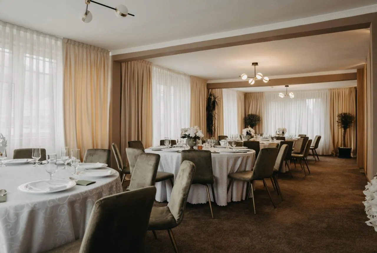 Salonul restaurantului cu mese rotunde și orhidee albe